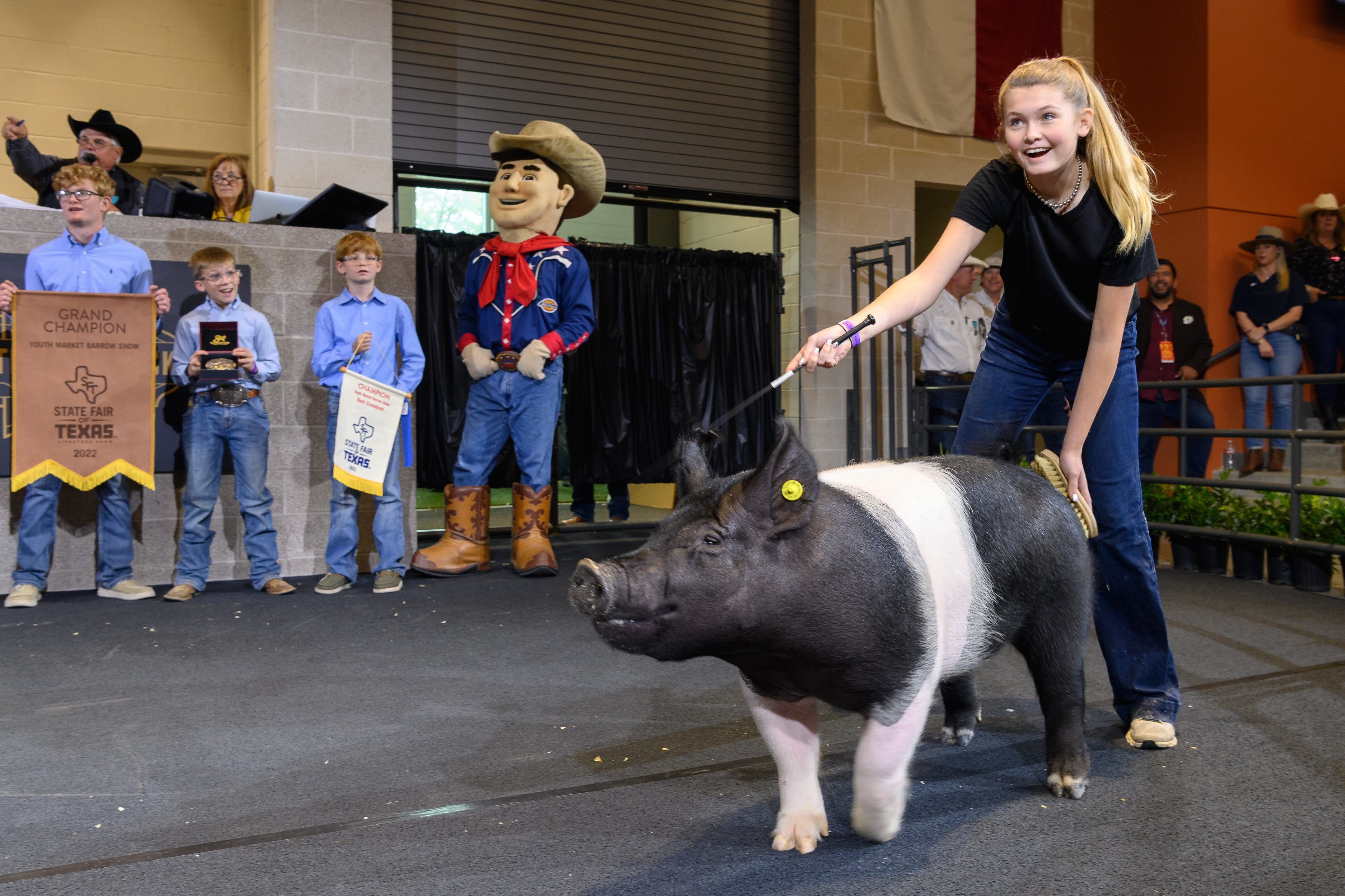 File photo: A woman stands beside a black-and-white pig at a fair demonstration.